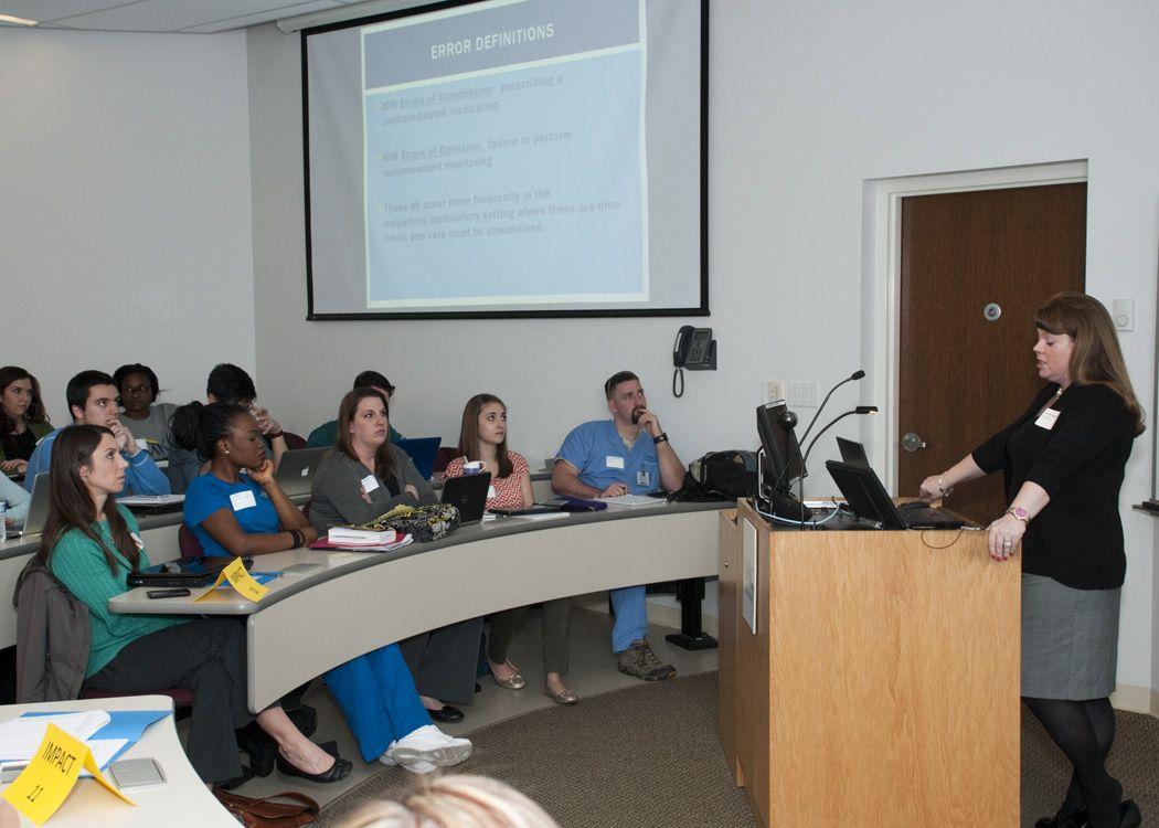 UMKC Nursing Graduate School Logo - Health Sciences students gather in team learning environment. UMKC