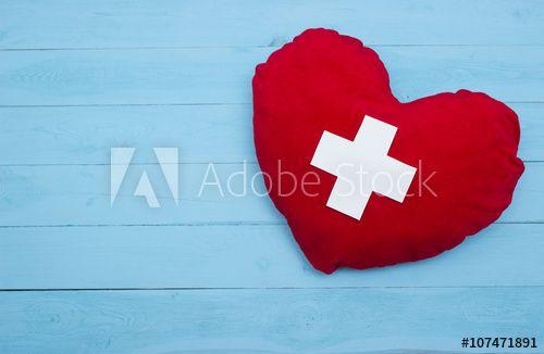 Red Heart with White Cross Logo - red heart with a white cross on blue background this stock