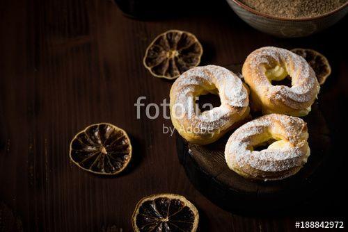 Three Orange Rings Logo - Three cream puffs on dark board with cinnamon sugar and orange rings