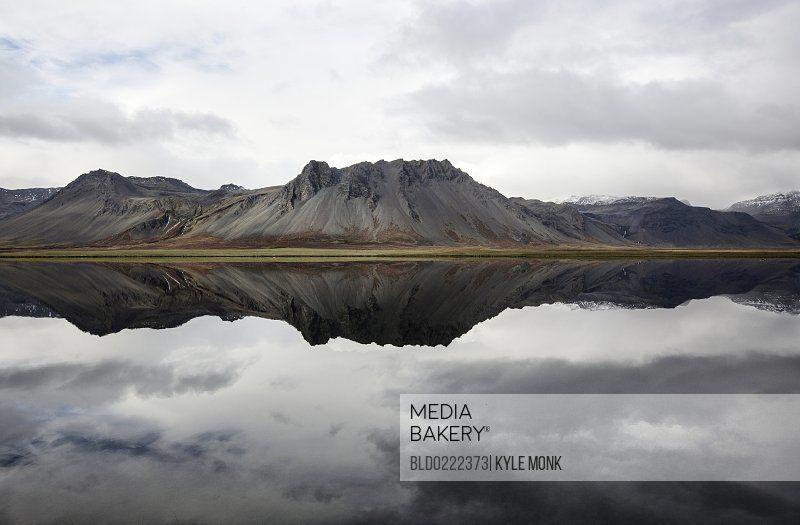 Mountain Reflection Logo - Mediabakery - Photo by Blend Images - Mountains reflecting in still lake