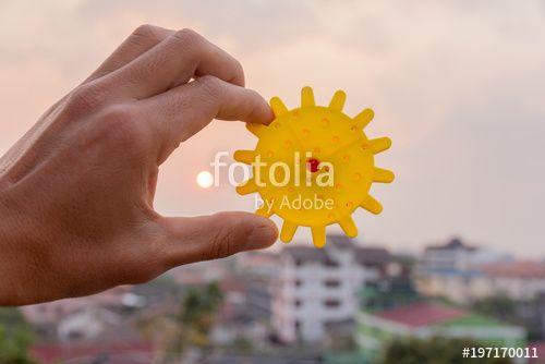 Man Holding Sun Logo - A man holding a gear piece against a background of the sun, a ...