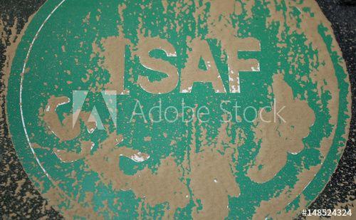 ISAF Logo - A ISAF logo is covered with sand at a German tank at camp Warehouse ...