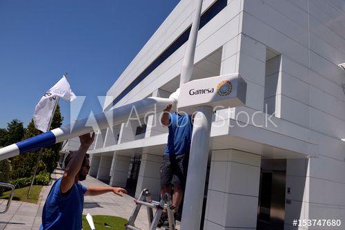 Gamesa Logo - Workers remove a model of a turbine with the Gamesa logo on it near