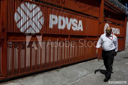 Pdvsa Logo - A man walks past a gate with the corporate logo of the state oil ...