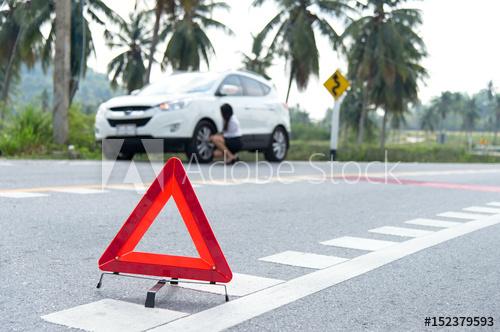 Broken Red Triangle Logo - Business woman with a broken car calling for assistance. Focus is