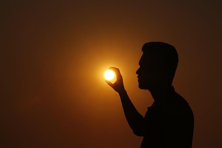 Yellow Man Holding Sun Logo - Royalty-Free photo: Forced perspective photo of silhouette of man ... - Yellow Man Holding Sun