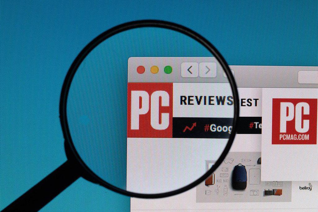 PCMag Logo - PCMag.com logo under magnifying glass. ✅ Marco Verch is a P