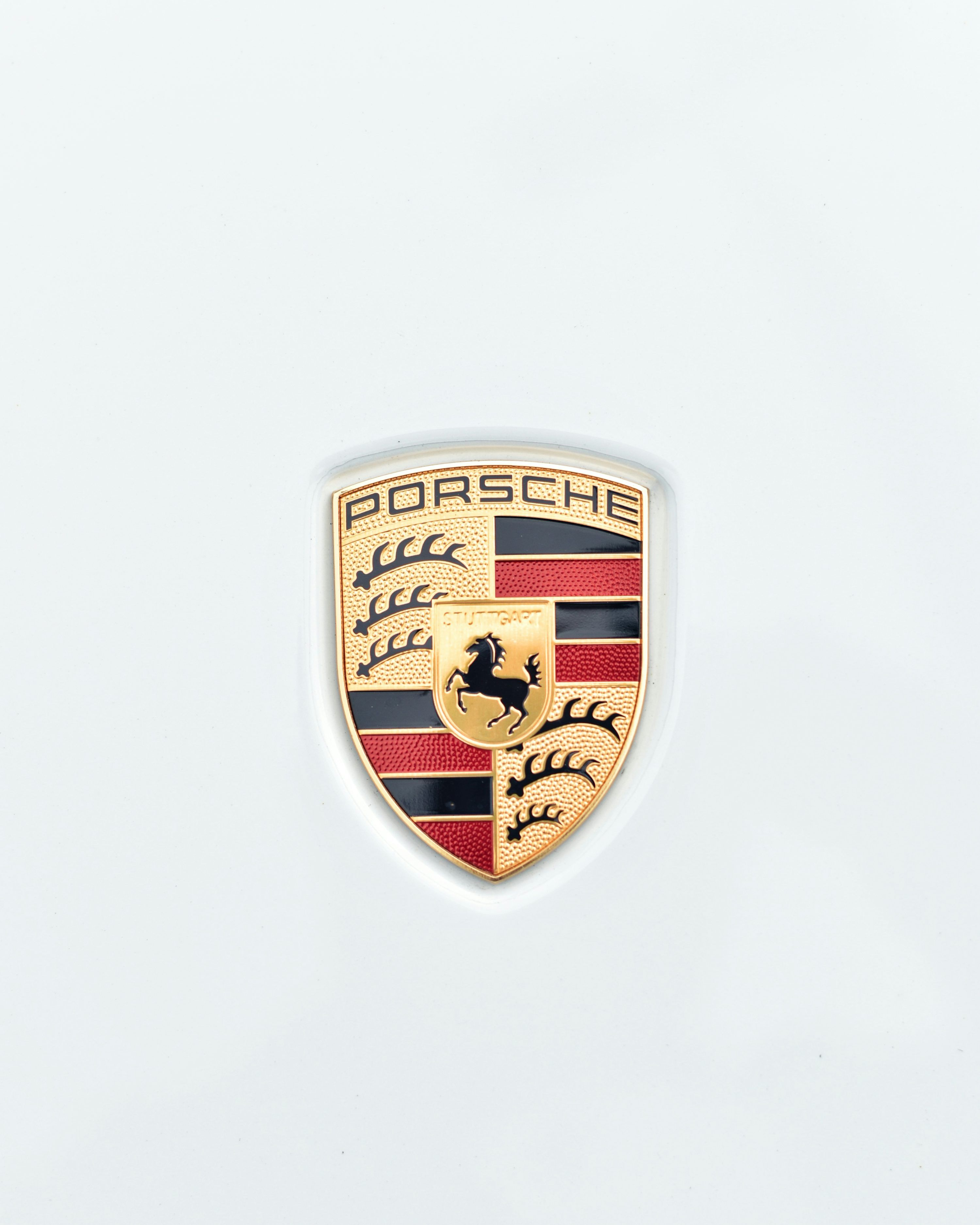Porsche Logo - A porsche emblem on a white background photo – Free Phone wallpaper Image  on Unsplash