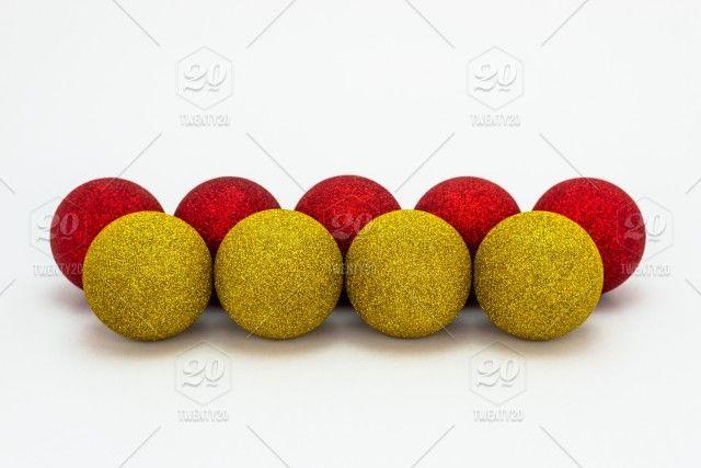 Red Ball with White Cross Logo - Five red and four yellow Christmas baubles, lies in a row isolated ...