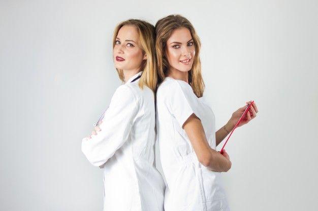 Two Women Back to Back Logo - Two pretty young women doctors, nurses standing back to back in