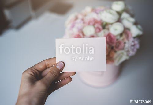 Hand Holding Flower Logo - Close-up of female hand holding blank craft business card with empty ...