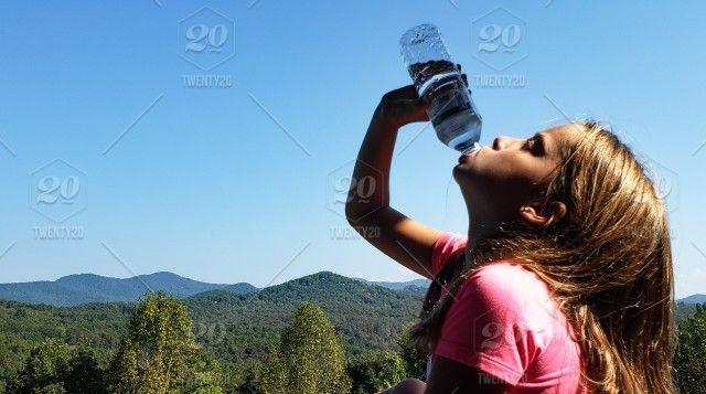 Pink Water with Mountains Logo - Little girl is staying healthy and hydrated by drinking water from a