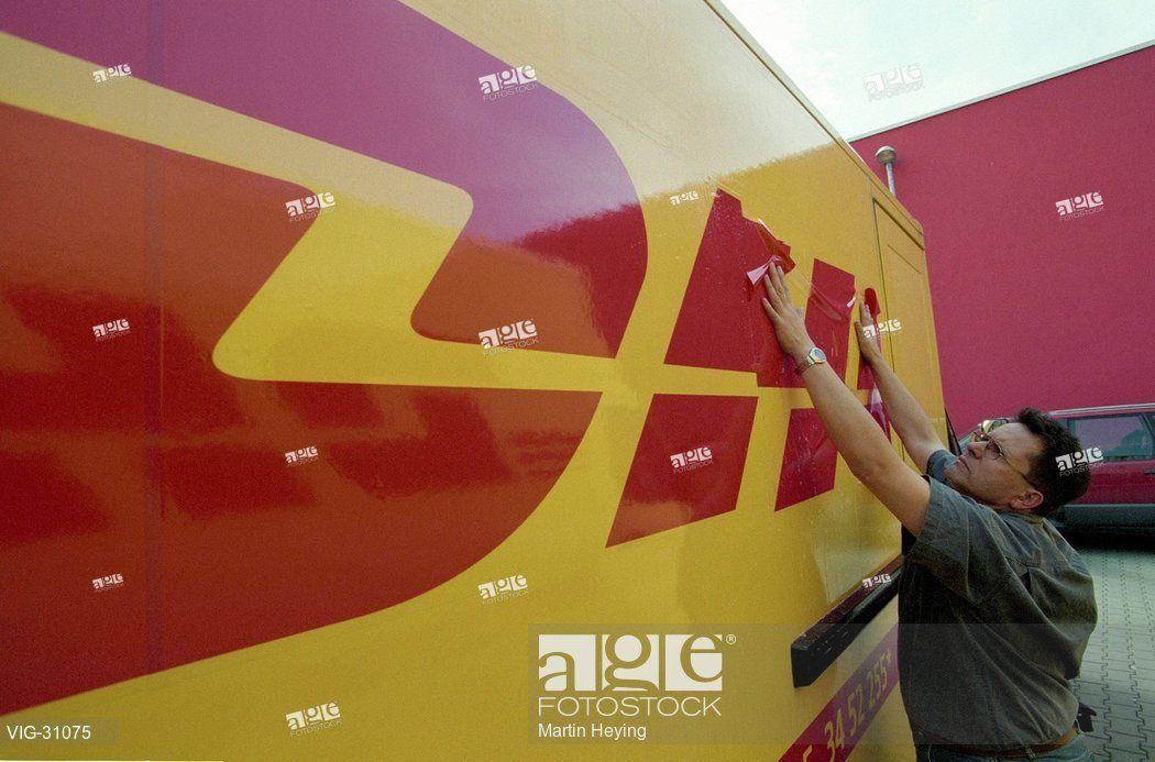 DHL New Logo - A man is fixing the new logo of DHL, the new courier service of the ...