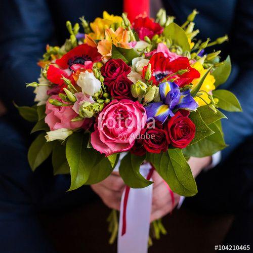 Red White and Yellow Flower Logo - wedding flowers, groom holds bouquet of white, blue, yellow flowers