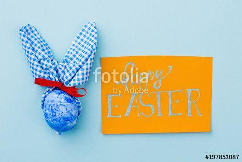 Blue Orange Red Ribbon Logo - Easter greeting card on blue background. Handmade Easter bunny