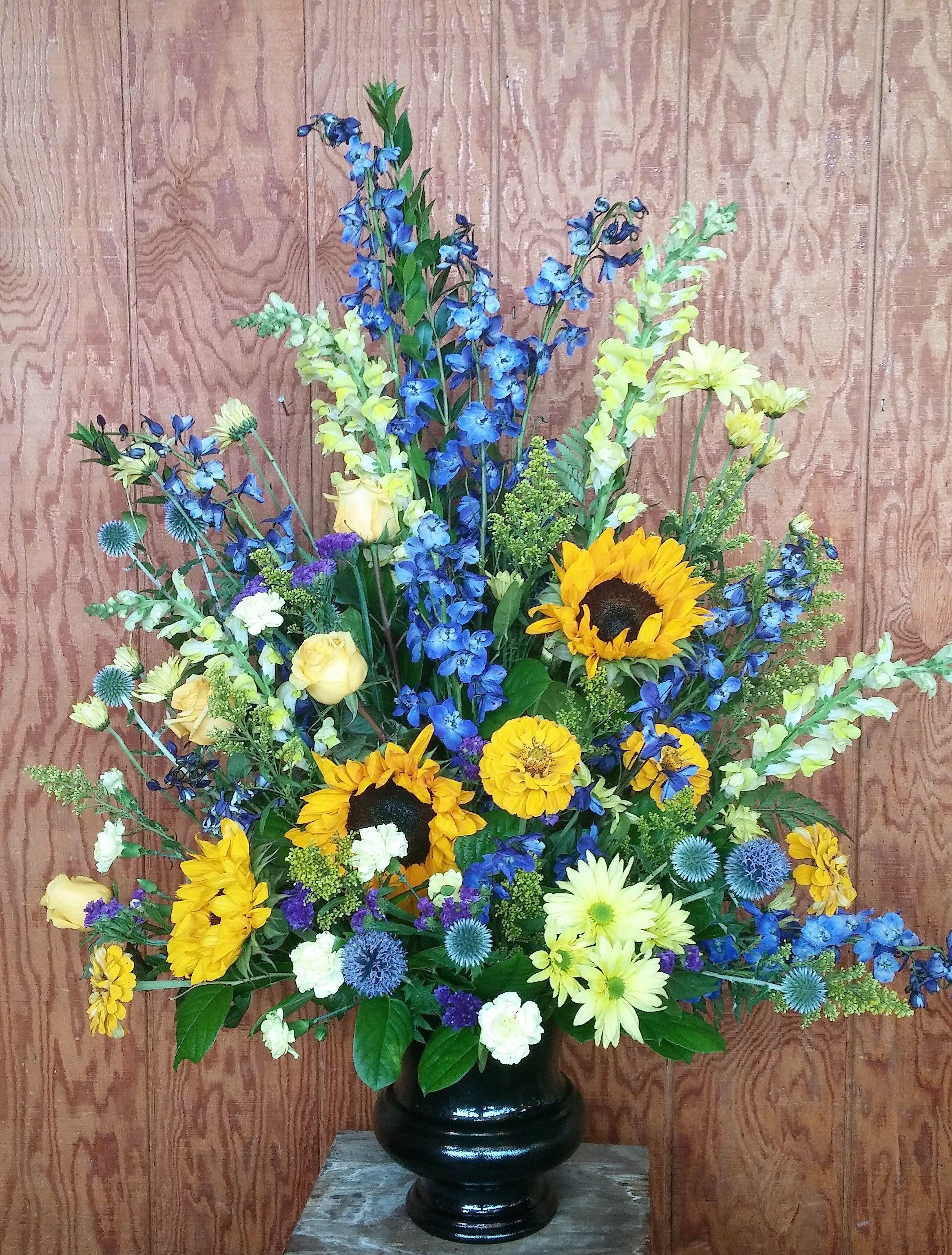 Blue Flower U Logo - tall podium arrangement. U of M flower arrangement, blue delphinium ...