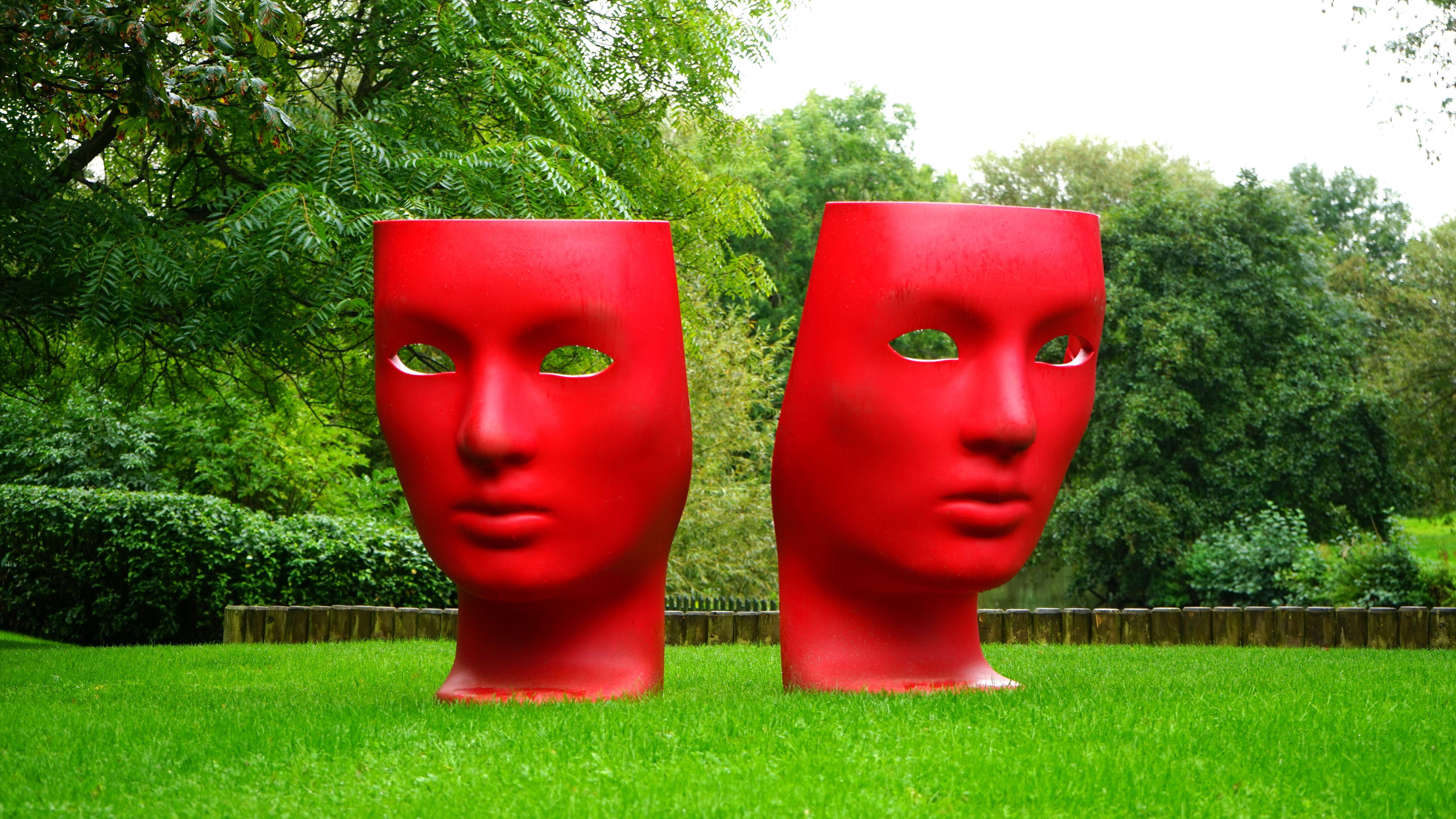 Red Face Statue Logo - Red Human Face Monument on Green Grass Field · Free Stock Photo