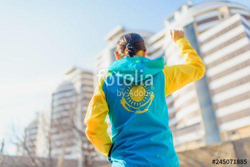 Yellow Blue Eagle Logo - A man stands with his back in a yellow-blue sports jacket against ...