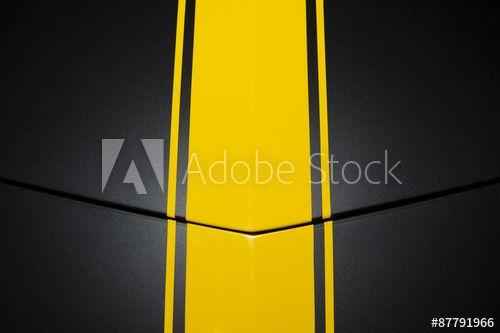 Vertical Line Car Logo - Surface of black sport sedan car, metal hood with yellow vertical