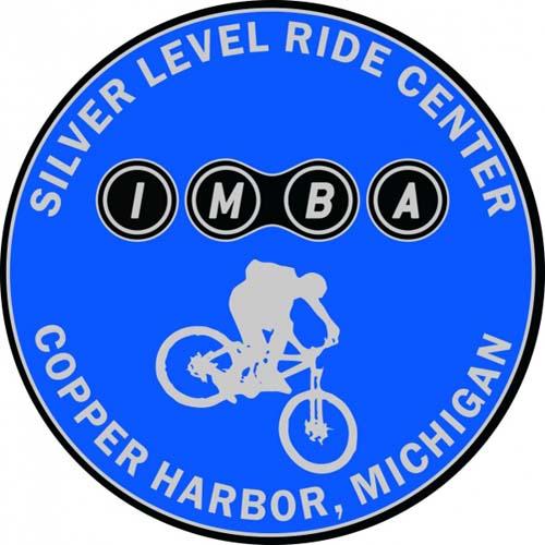 Circle in Silver with Blue Center Logo - IMBA Silver Level Ride Center Michigan | Keweenaw Adventure Company