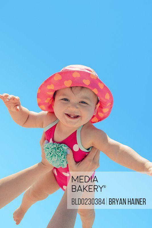 Woman Holding Baby Blue Logo - Mediabakery - Photo by Blend Images - Woman holding baby girl ...