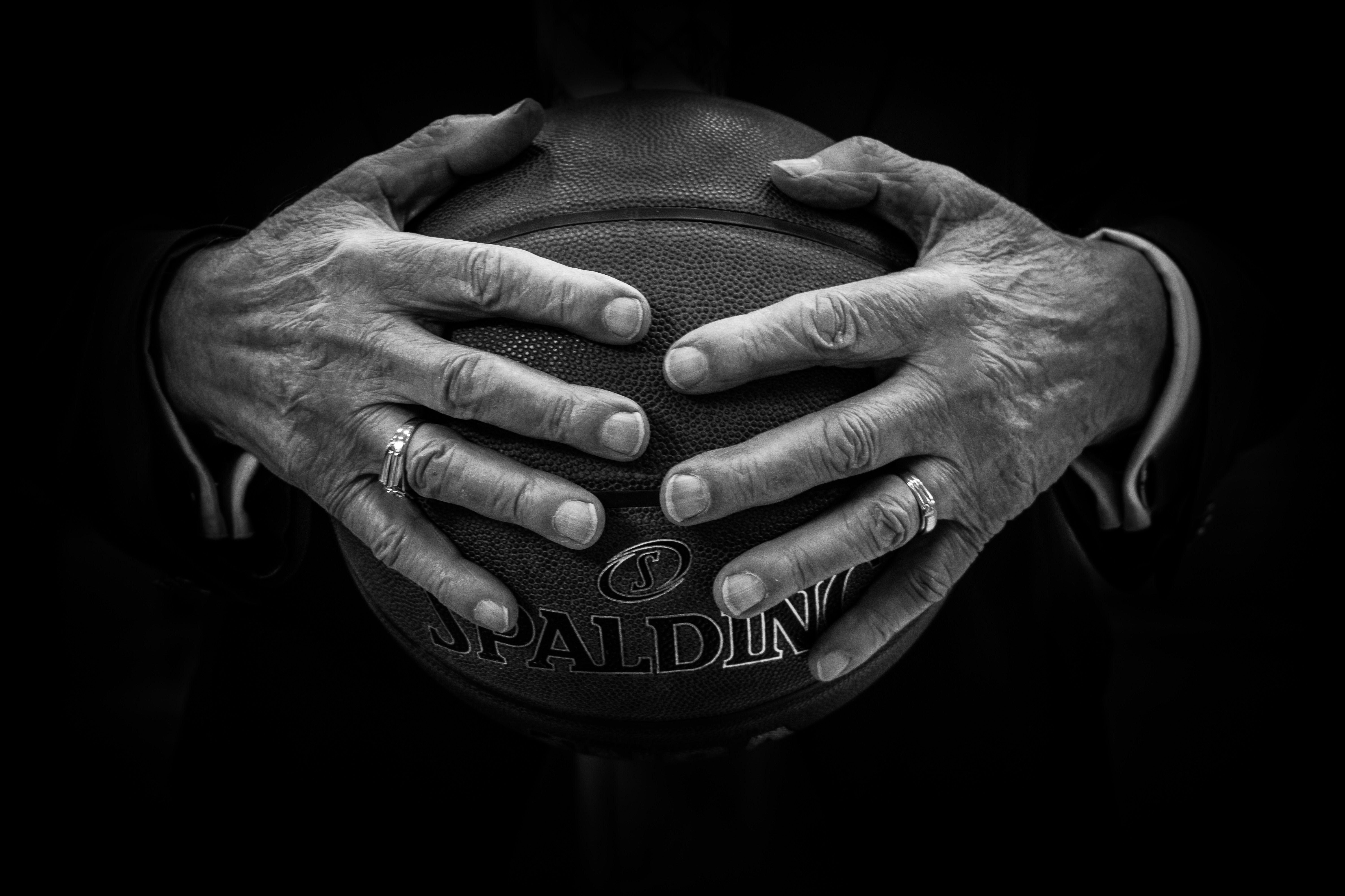 2 Hands -On Ball Logo - grey scale photo of two hands holding a spalding basketball free
