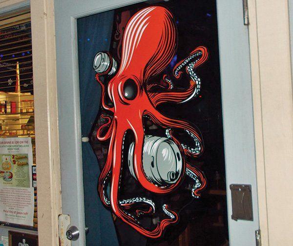 Red Octopus Logo - Photo: On the wall, a giant red octopus has wrapped his tentacles ...
