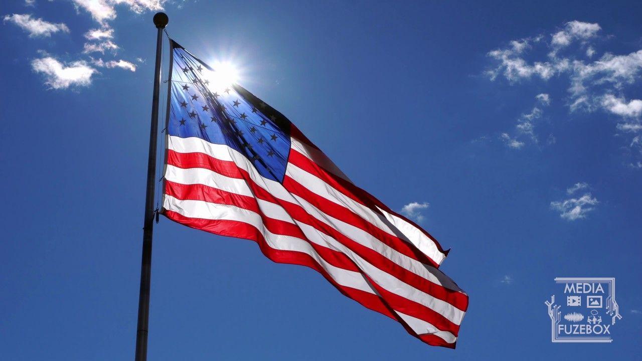 American Flag Sun Logo - American Flag waving against a blue sky with sun glowing from behind ...