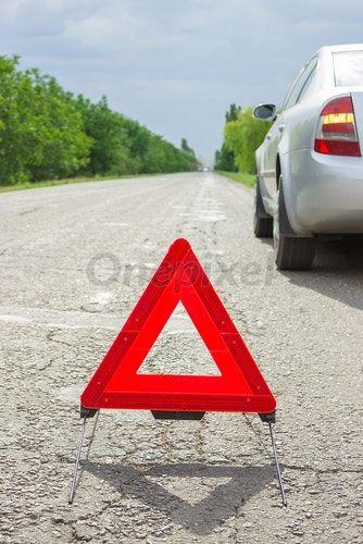 Red Triangle Auto Logo - Red triangle of a car on the road. Breakdown of