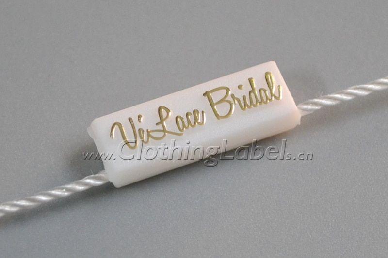 Seal Clothing Logo - Hang tag string, plastic seal, white background with gold logo ...