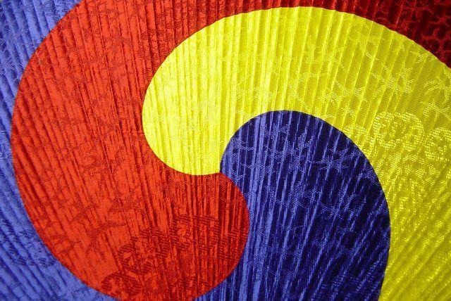 Blue Fan and Yellow Logo - Red, blue, and yellow waves on a traditional Sam Taeguk fan